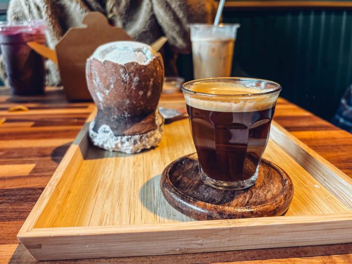 Coffee served beside a vessel of asin tibuok on a wooden tray